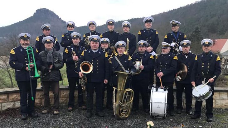 Hohnsteiner Blasmusikanten beim Frachteinholen 2018 in Prossen mit Instrumenten und Schiffsmodellen